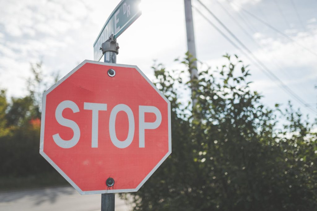 A red stop sign on a pole against a blue sky with light clouds. Outdoor scene.